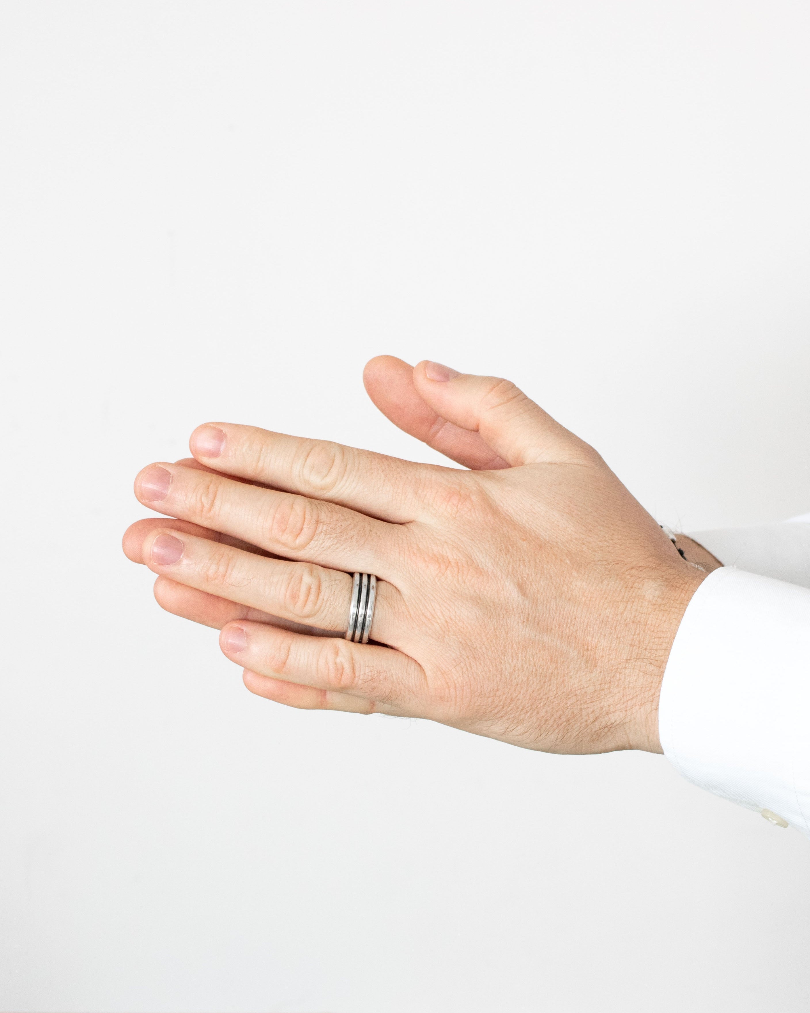 Hand wearing a ring on a plain background