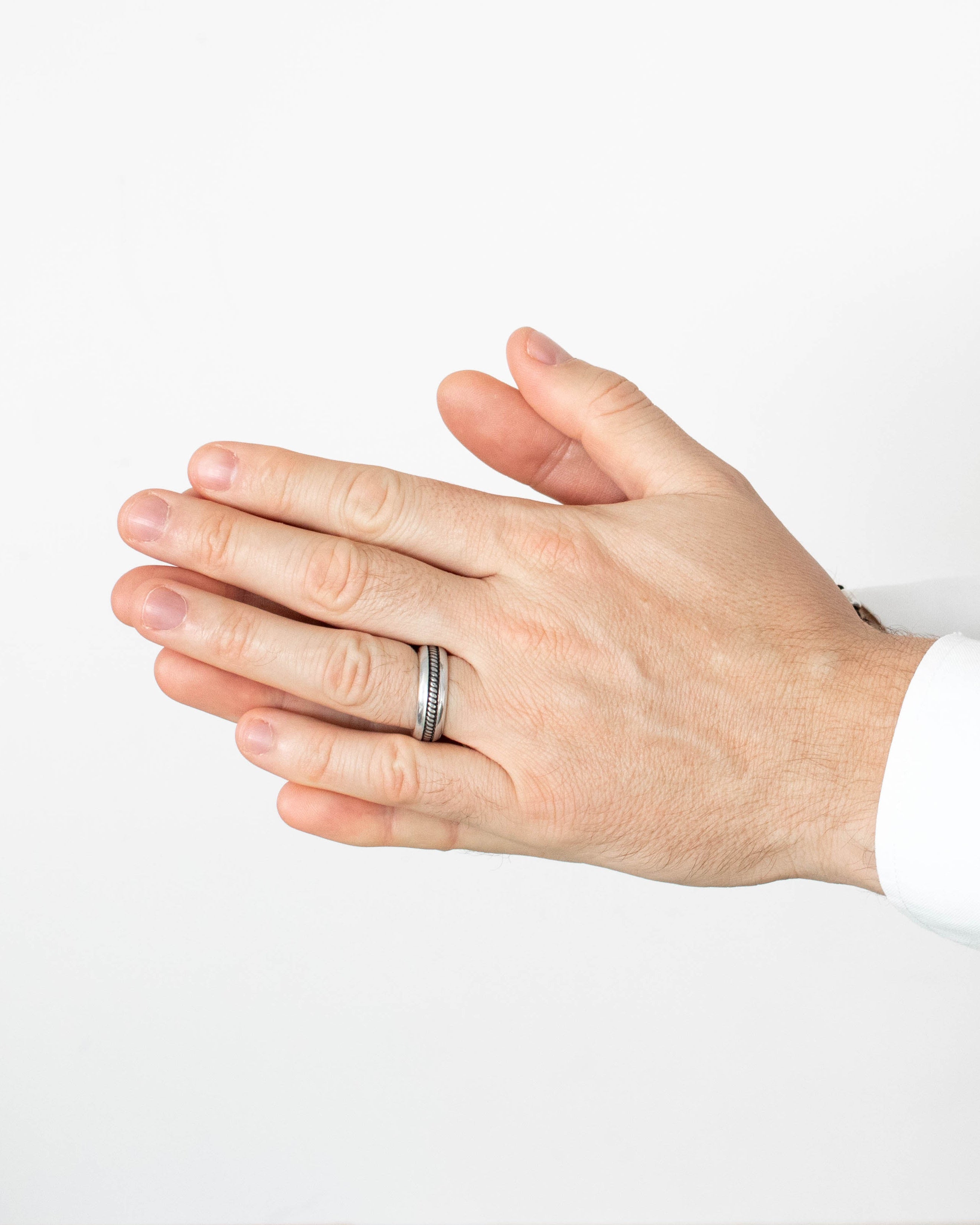 Close-up of a hand wearing a ring on a white background