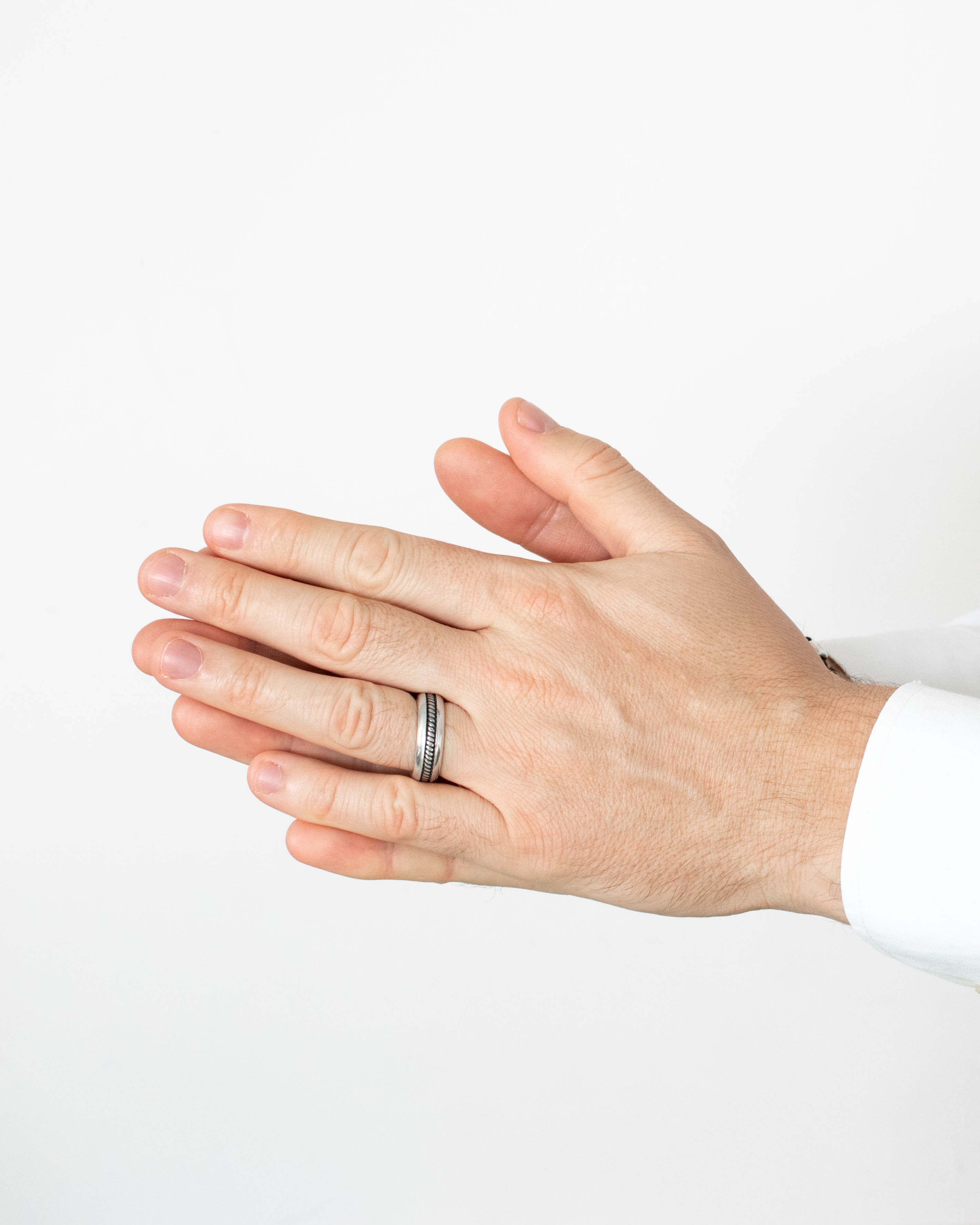 Close-up of a hand wearing a ring on a white background