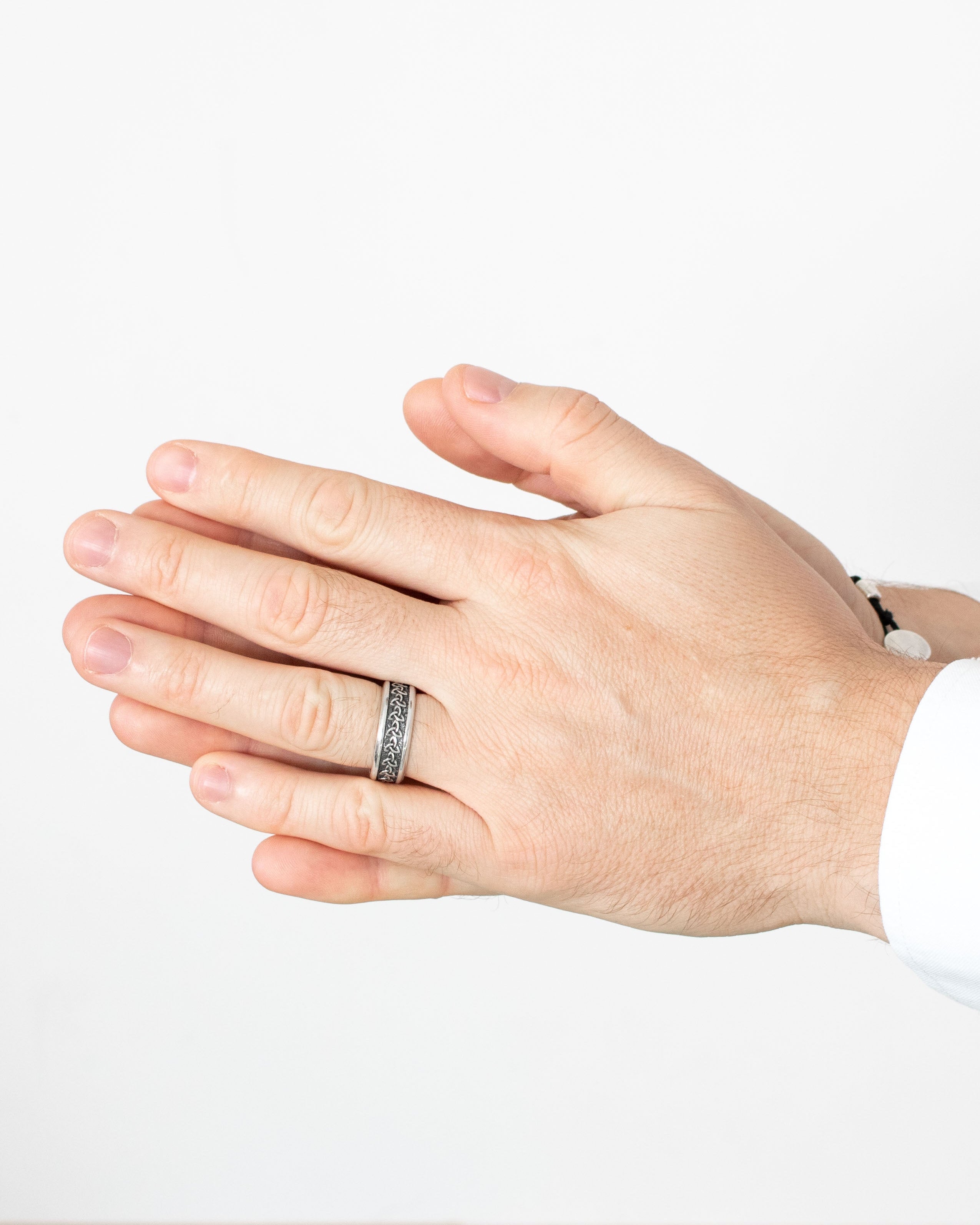 Hand wearing a silver ring on a white background