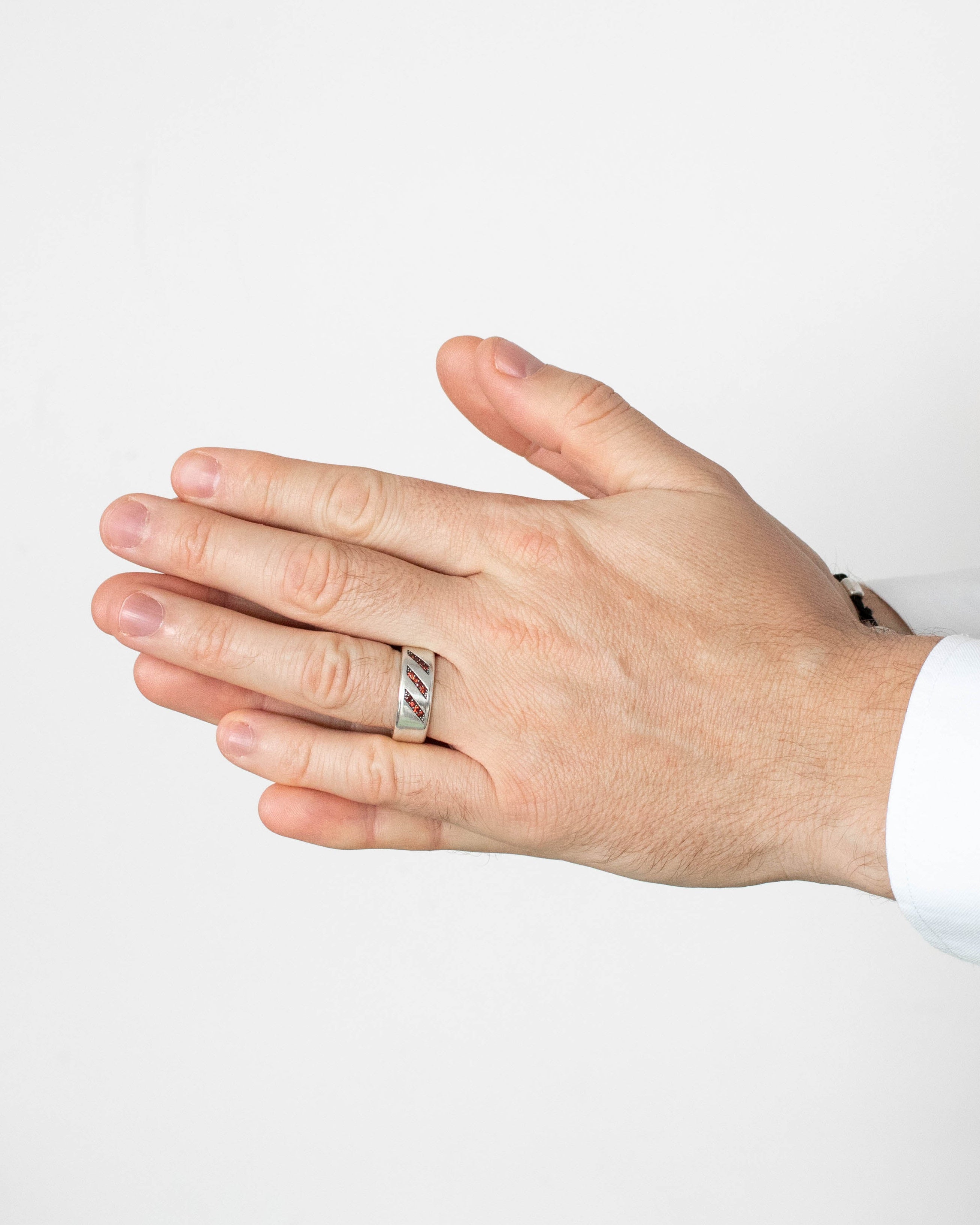 Hand wearing a silver ring on a white background