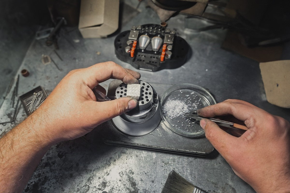 The atmosphere in the STRONZEN workshop during the creation of a large signet ring. The photo captures our jeweler as he sets each stone by hand.