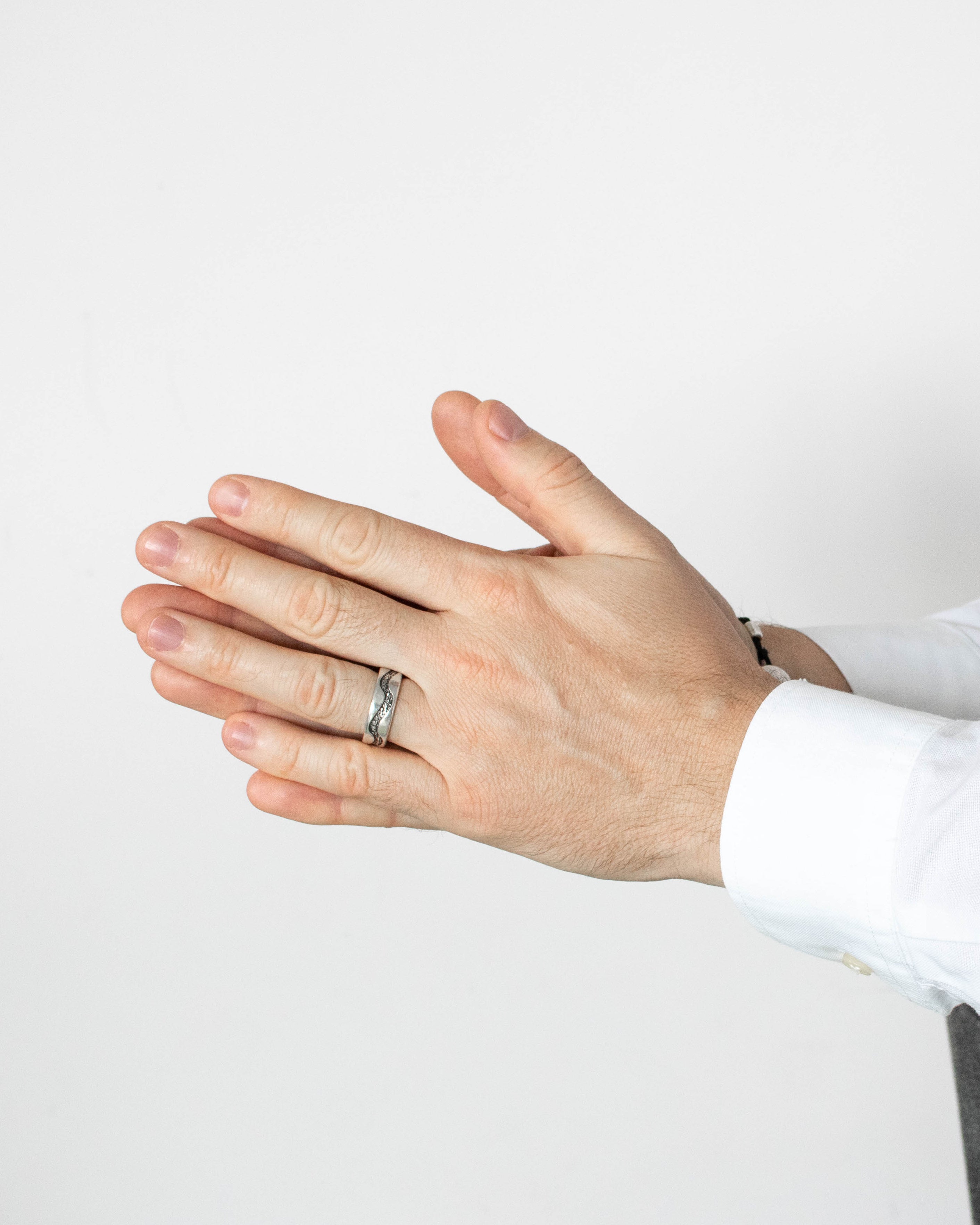 Hand wearing a ring on a plain background