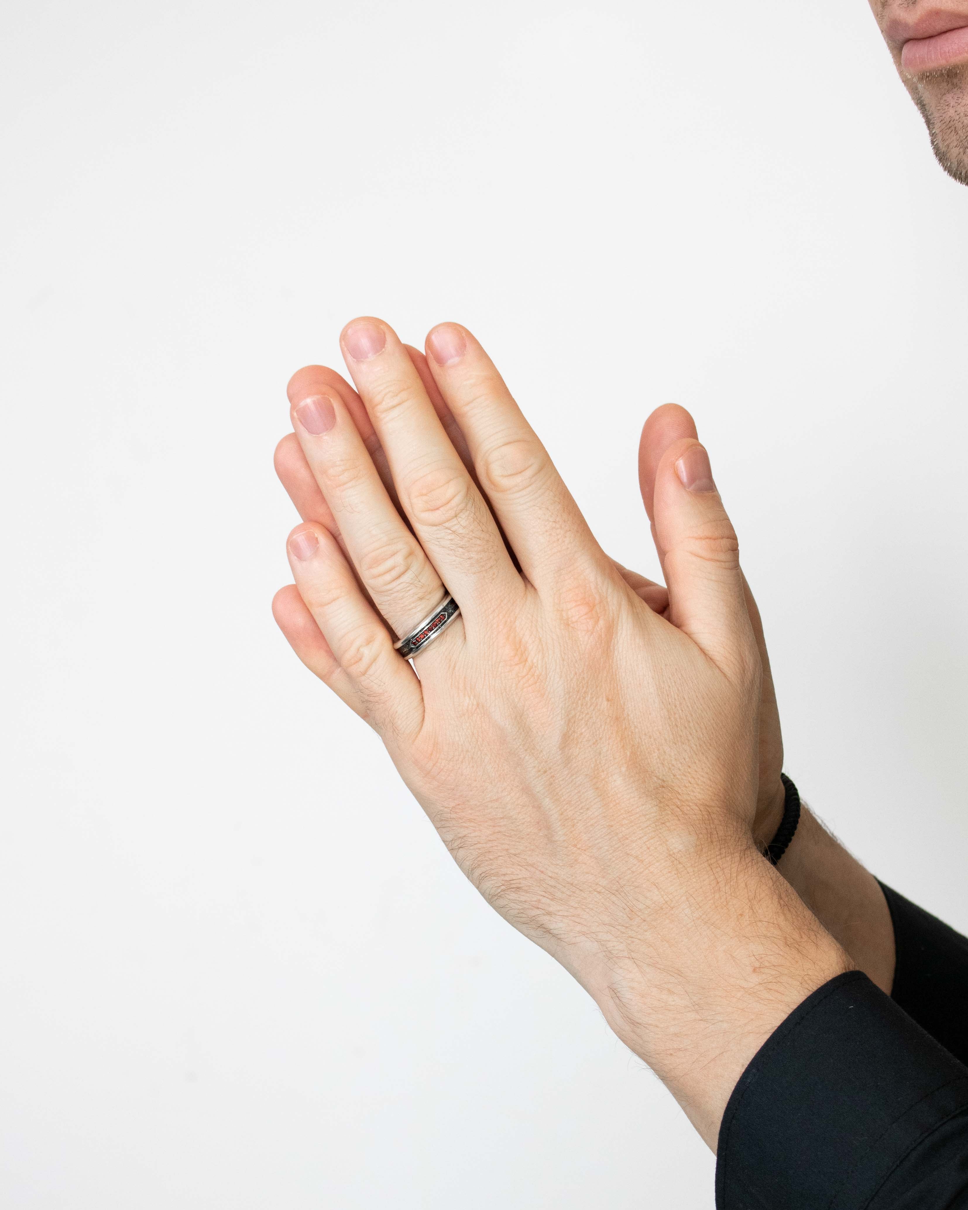 Person wearing a ring on a plain background