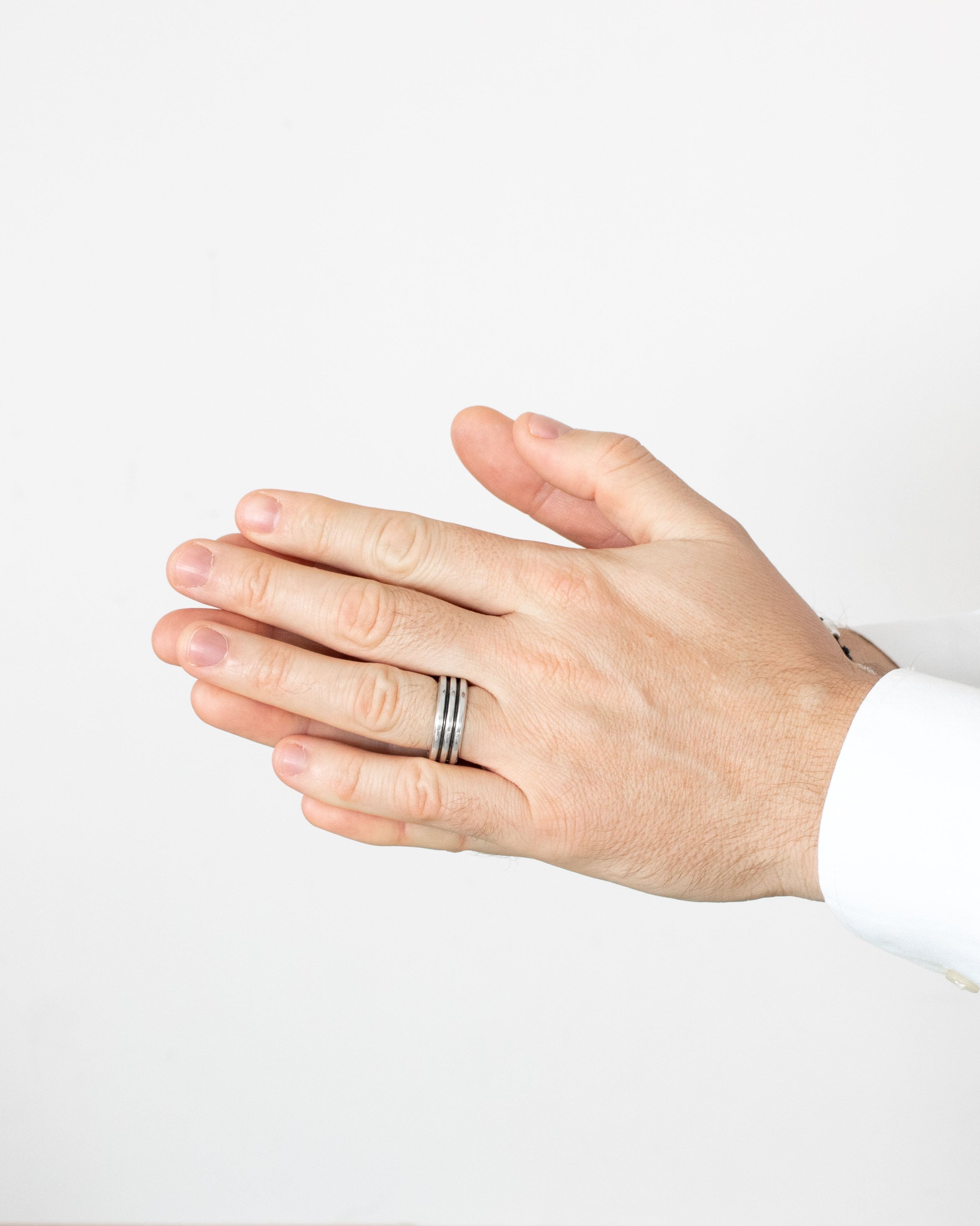 Hand wearing a ring on a plain background