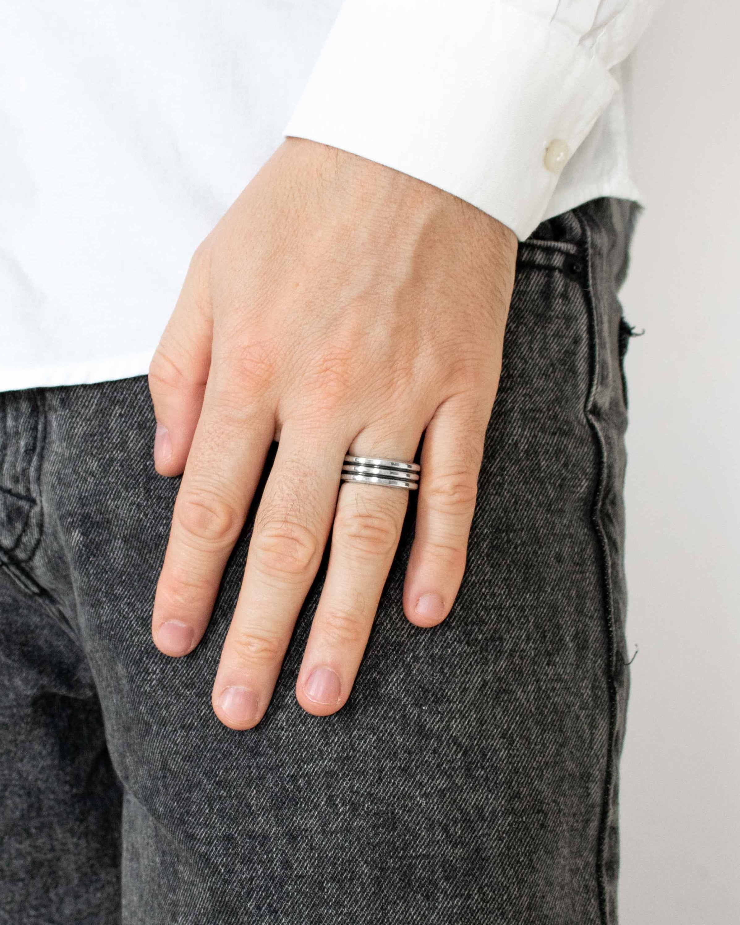 Person wearing a silver ring on a white background