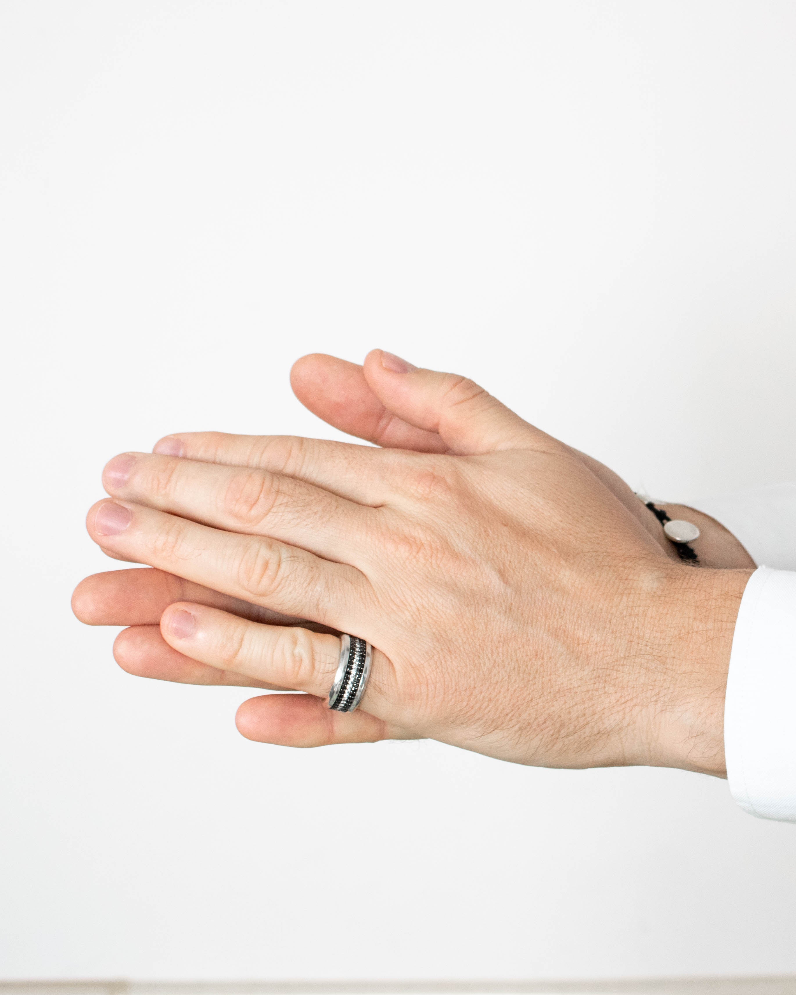 Close-up of a person wearing a ring with a white background
