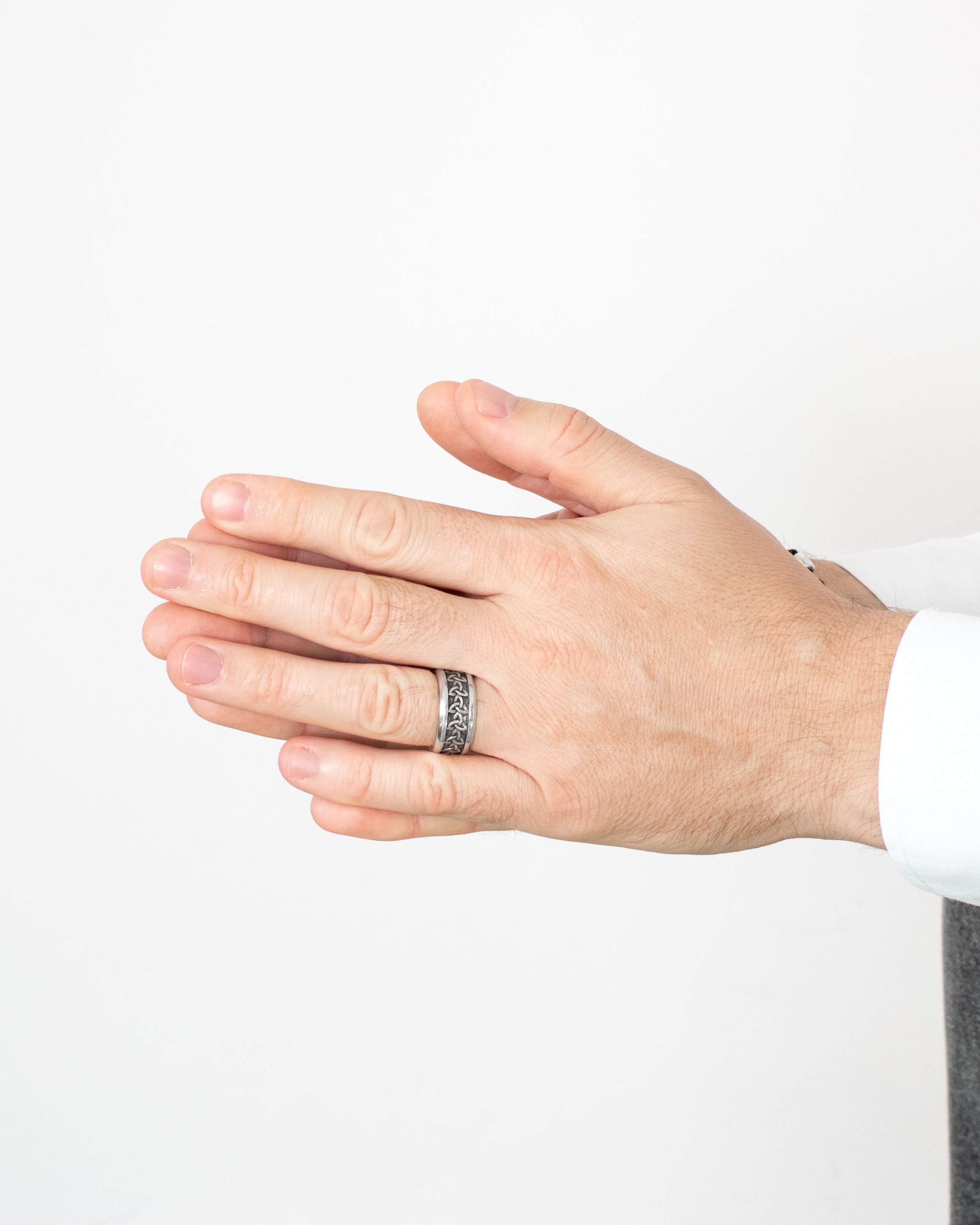 Hand wearing a ring on a plain background