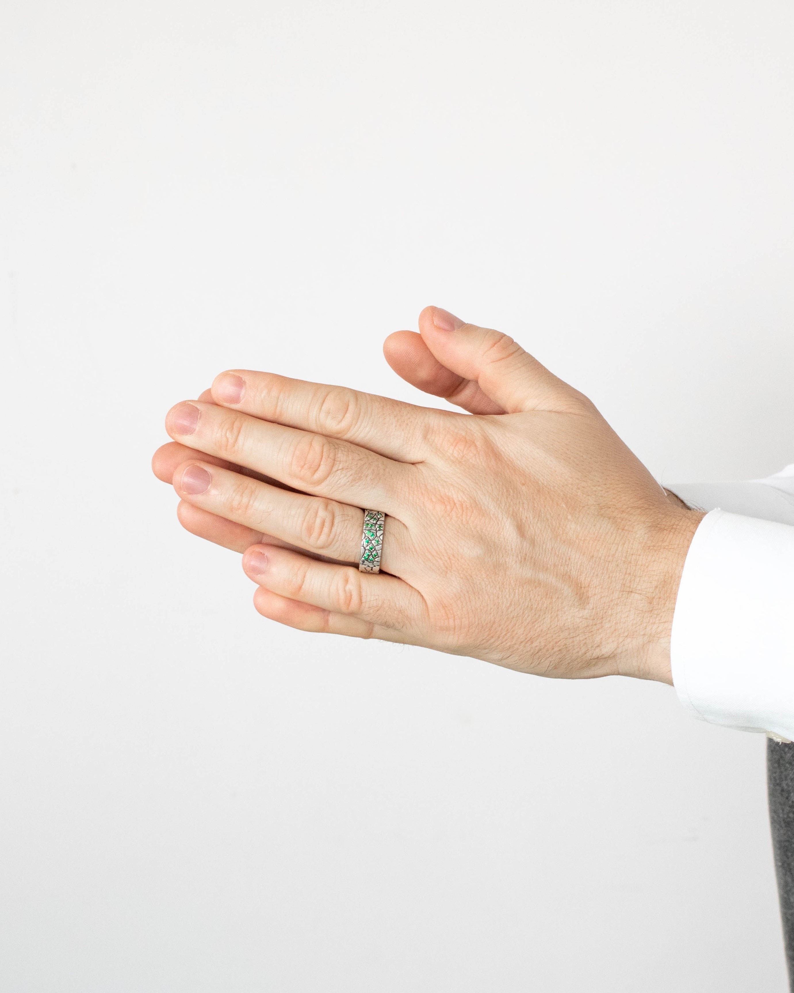 Hand wearing a ring on a plain background
